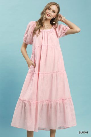 Women wearing a pink maxi dress against a blue background.