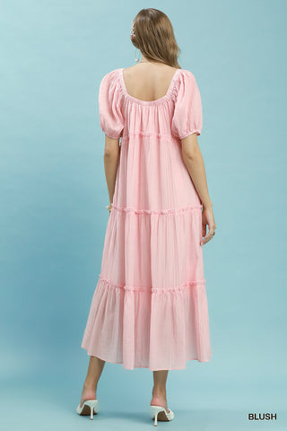 Women wearing a pink maxi dress against a blue background.