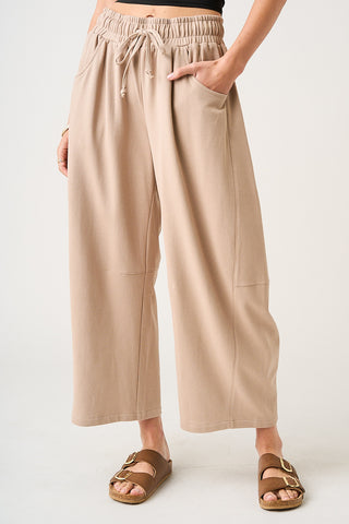 Beige wide-leg pants worn by a person on a white background