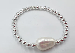 Bracelet with silver beads and a large pearl on a light gray background