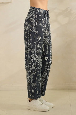 Dark blue pants with white floral pattern worn by a person on a beige background