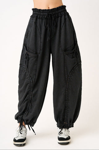 Black cargo pants worn by a person on a white background