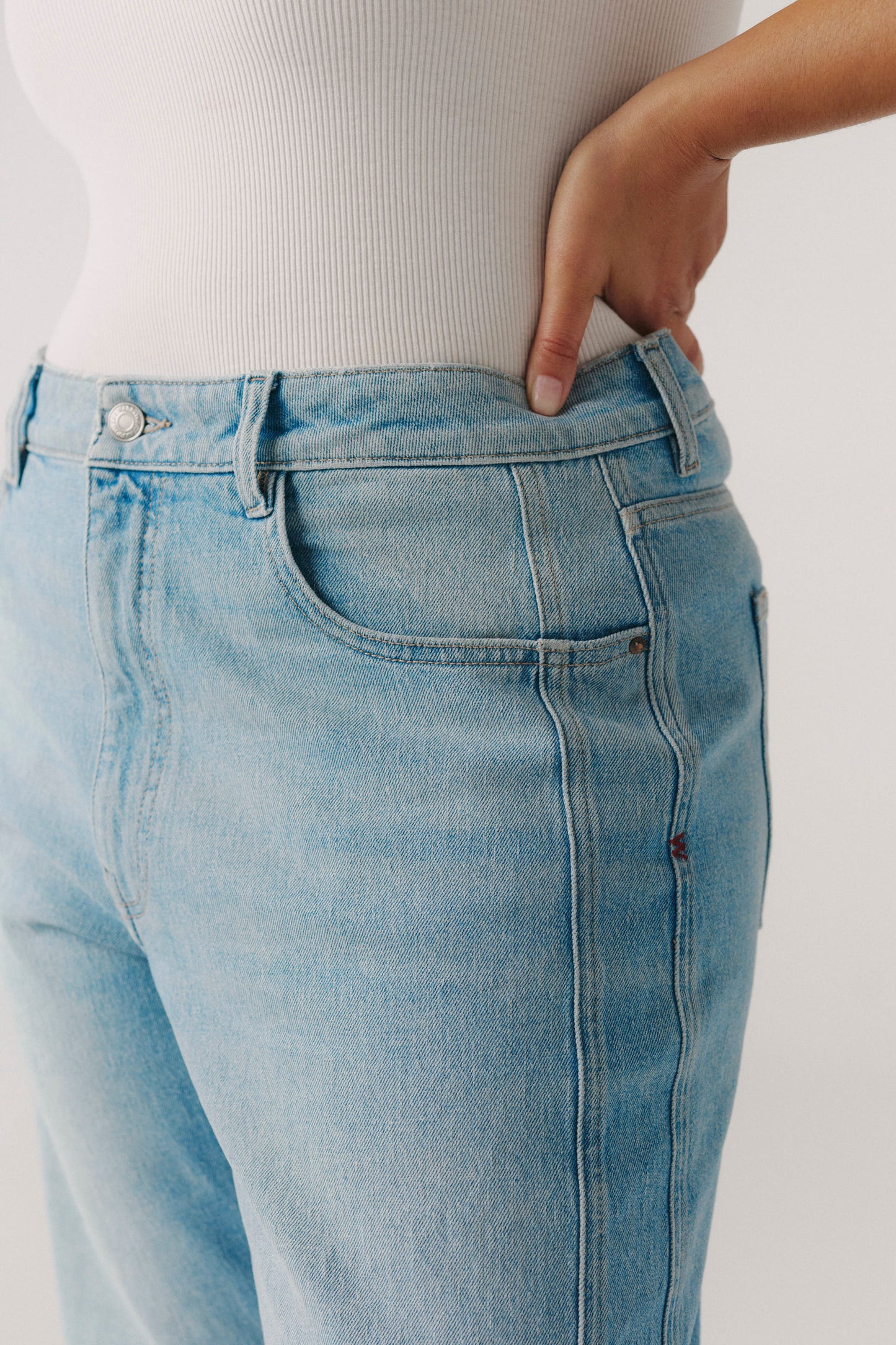 Light blue jeans worn by a person on a plain background