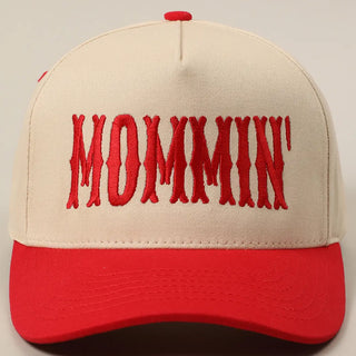 Beige and red cap with 'MOMMIN'' text on a neutral background