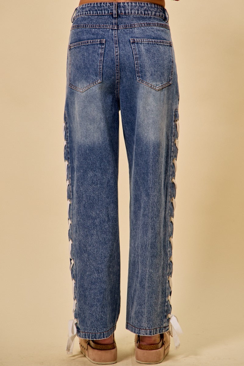 Blue jeans with lace detailing on a beige background
