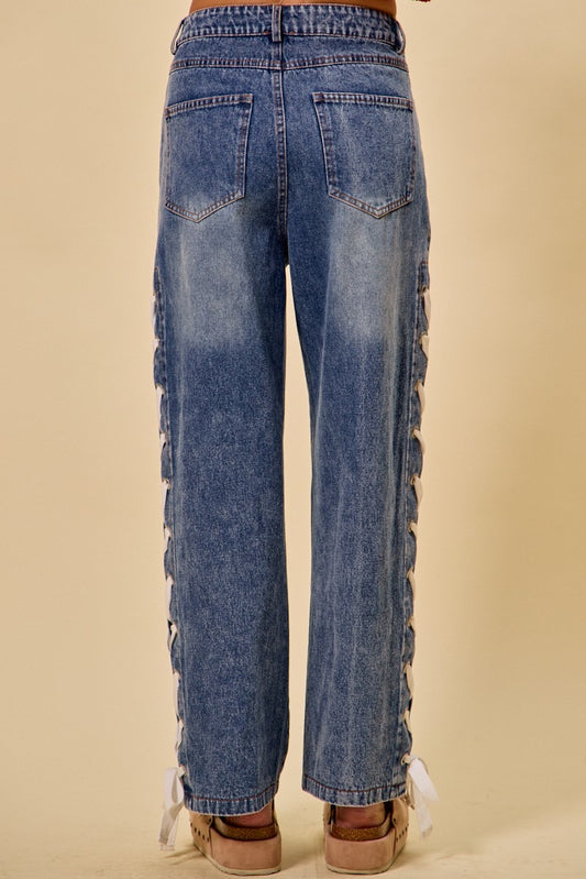 Blue jeans with lace detailing on a beige background