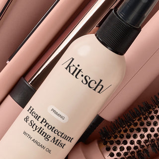 Kitsch heat protectant and styling mist bottle with a hairbrush on a brown background