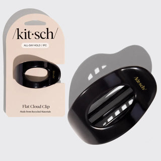 Black hair clip with 'kit·sch' branding next to its packaging on a light gray background