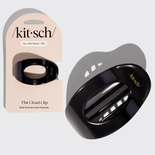Black hair clip with 'kit·sch' branding next to its packaging on a light gray background