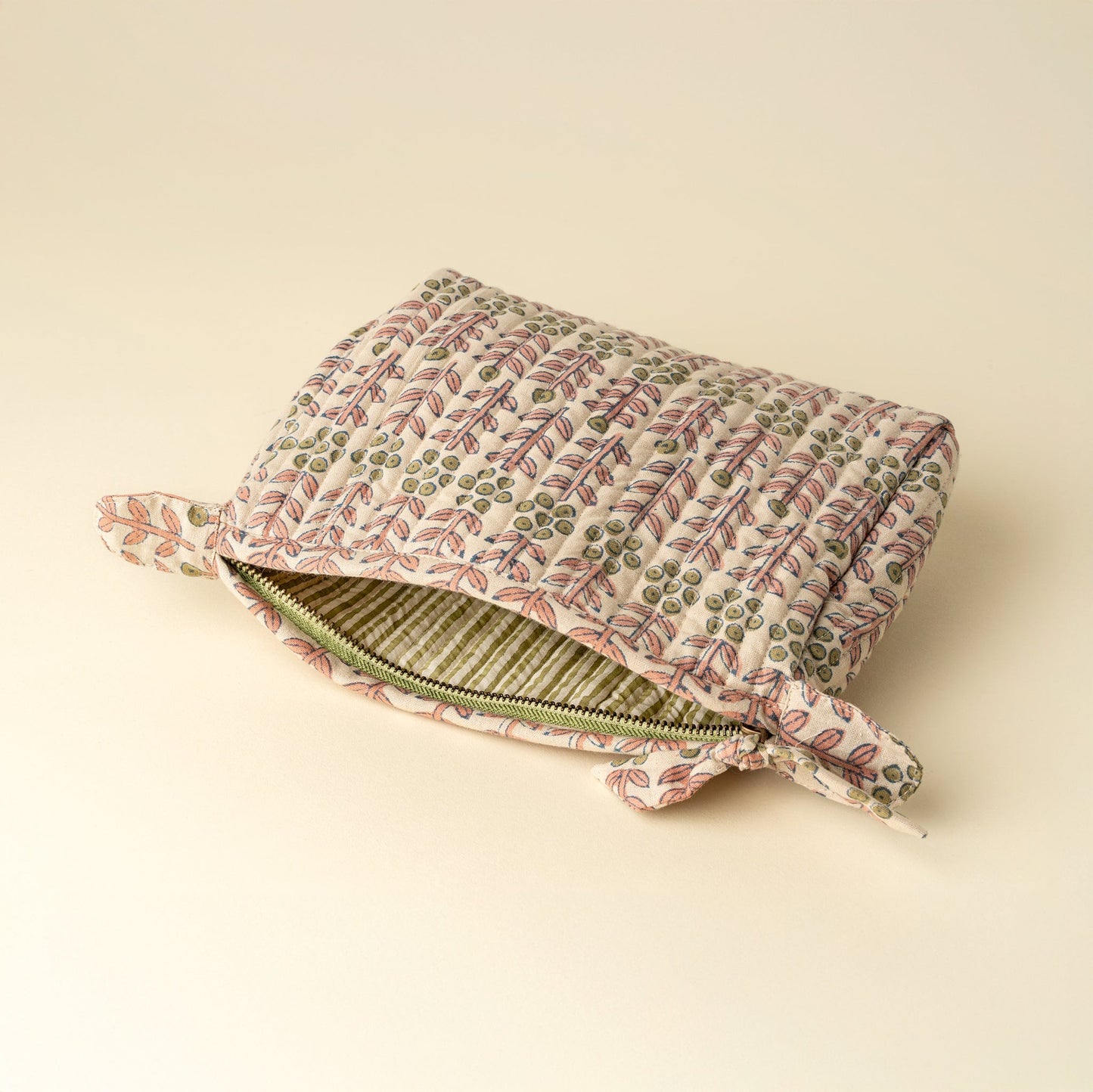 Floral-patterned clutch bag on a beige background