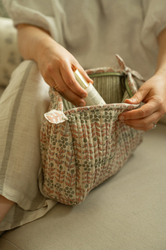 Person holding a patterned fabric bag with a neutral background