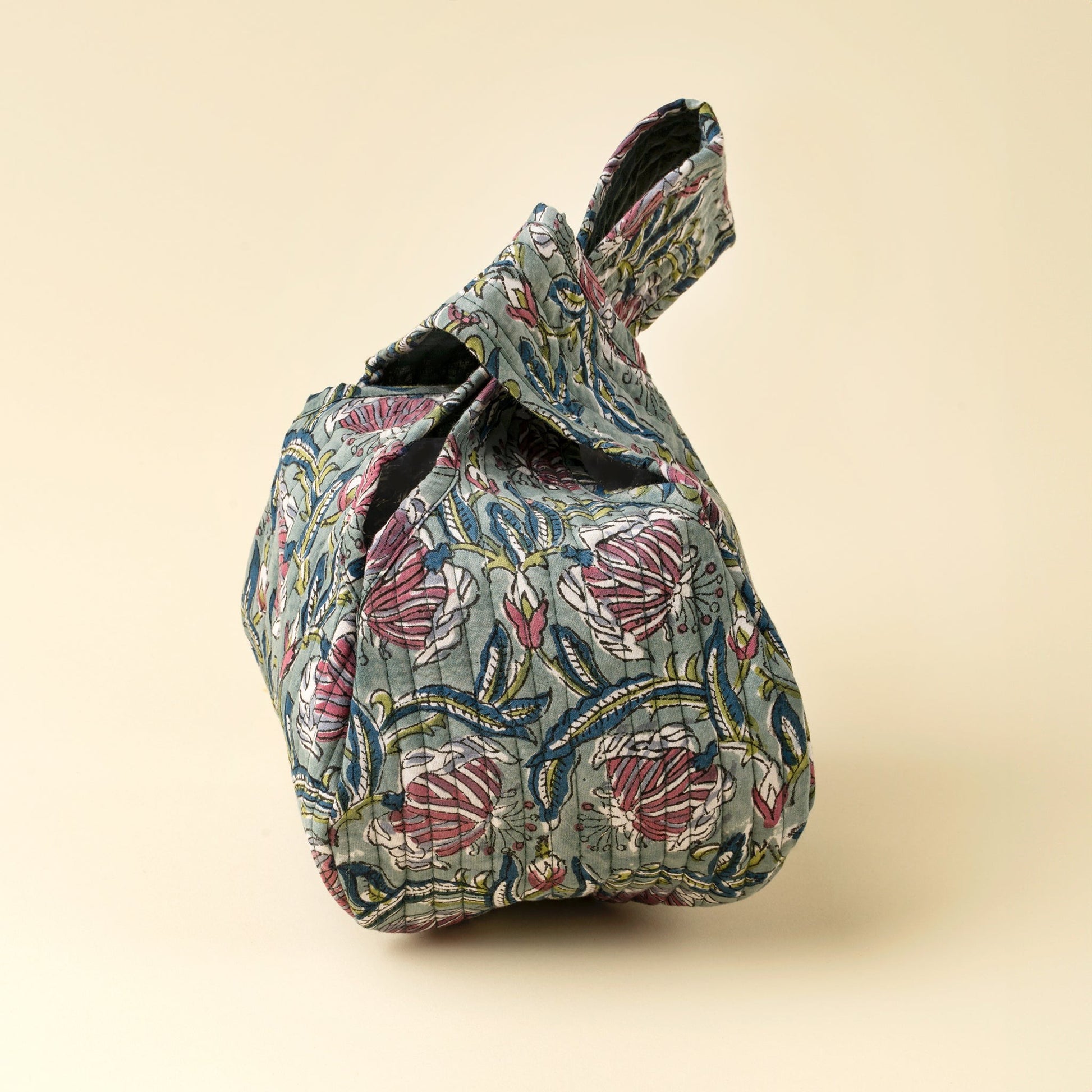 Floral-patterned fabric bag on a beige background
