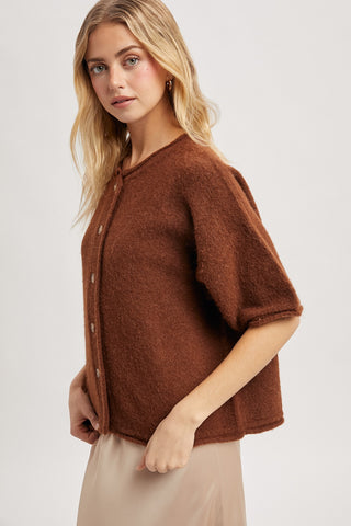 Woman wearing a brown knitted cardigan on a white background