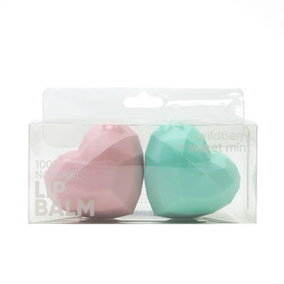 Two heart-shaped lip balms, one pink and one green, in clear packaging on a white background.