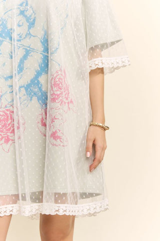 Women modelling a sage green mini dress with a lace overlay against a neutral photo backdrop.