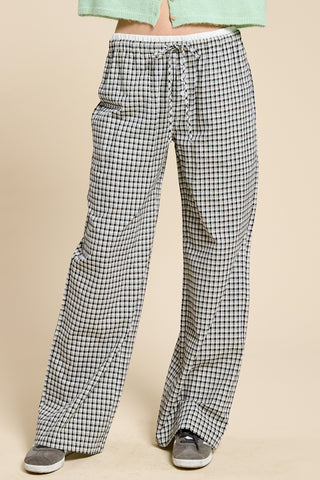 Checkered pants worn by a person on a beige background