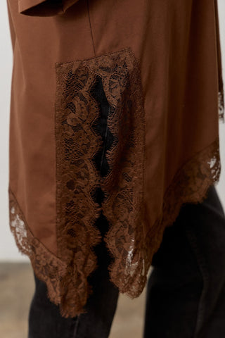 Women wearing a brown t shirt with Lace Trim against a neutral background. 