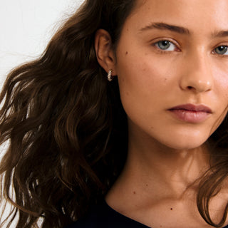 Close-up of a woman with wavy hair and a neutral expression