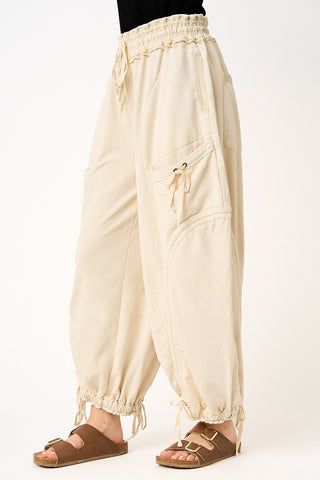 Beige baggy pants worn by a person on a white background