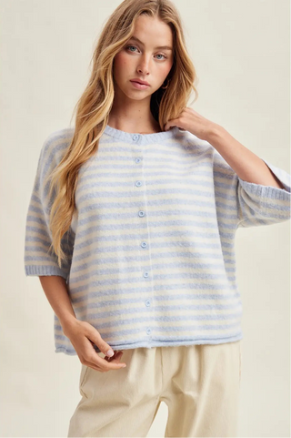 Woman wearing a blue and white striped shirt against a plain background