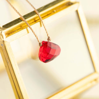 An up close image of the red strength necklace. 