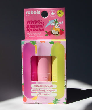 Packaged lip balm set with 'rebels' branding on a dark background