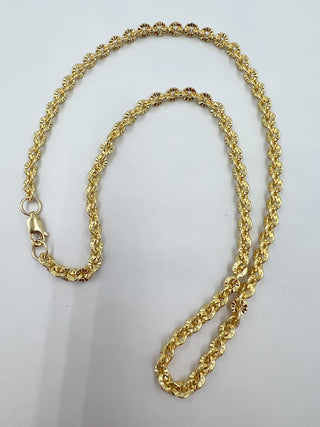 Gold chain necklace on a light gray background