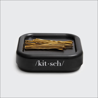 Black container with gold hair pins on a white background, branded 'kitsch'.