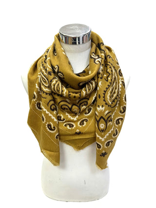 A mustard yellow bandana scarf with a black and white paisley pattern, draped on a white mannequin torso against a white background.