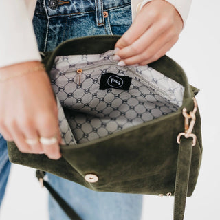 The interior of a green crossbody bag against a white photo background