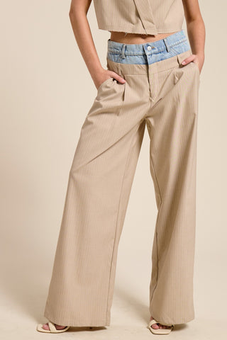 Person wearing beige wide-leg pants with a neutral background