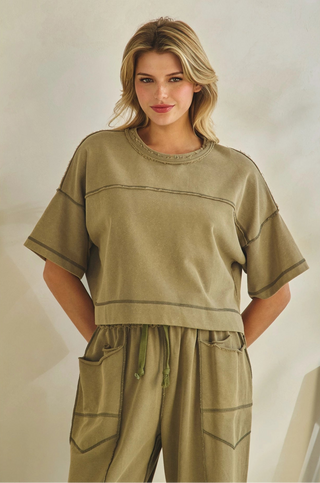 Woman wearing a green outfit with a neutral background