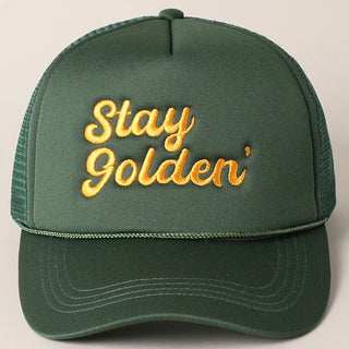 Green cap with 'Stay Golden' embroidery on a beige background