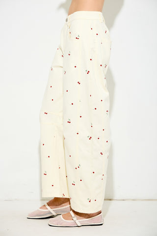 White pants with red pattern worn by a person on a white background