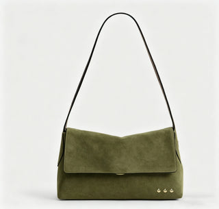 A green crossbody bag against a white photo background