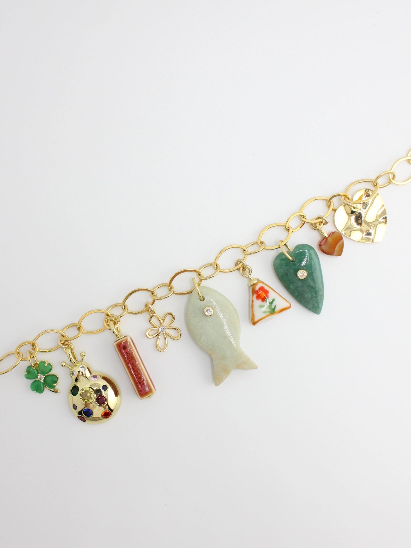 Gold bracelet with various charms on a white background