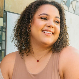 A woman wearing the red crimson necklace. 