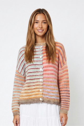 A woman modeling a fuzzy knit cardigan sweater with horizontal stripes in peach, orange, beige, and brown, featuring a button-up front and ribbed cuffs and hem.