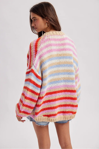 Woman wearing a colorful striped sweater on a plain background