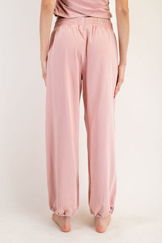 Pink satin pants worn by a person on a white background