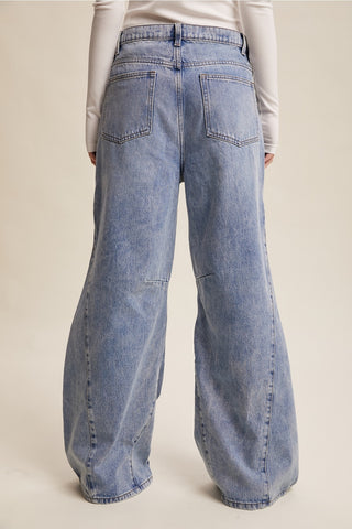Blue jeans worn by a person on a beige background