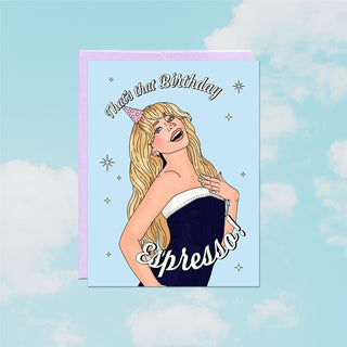 Birthday card with illustration of a woman wearing a nightgown and party hat, with text 'That's that Birthday Expresso' on a blue background.