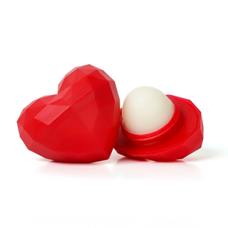 Red heart-shaped lip balm container with a white lip balm inside on a white background
