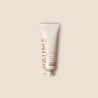 Tube of 'Paume' hand balm on a beige background