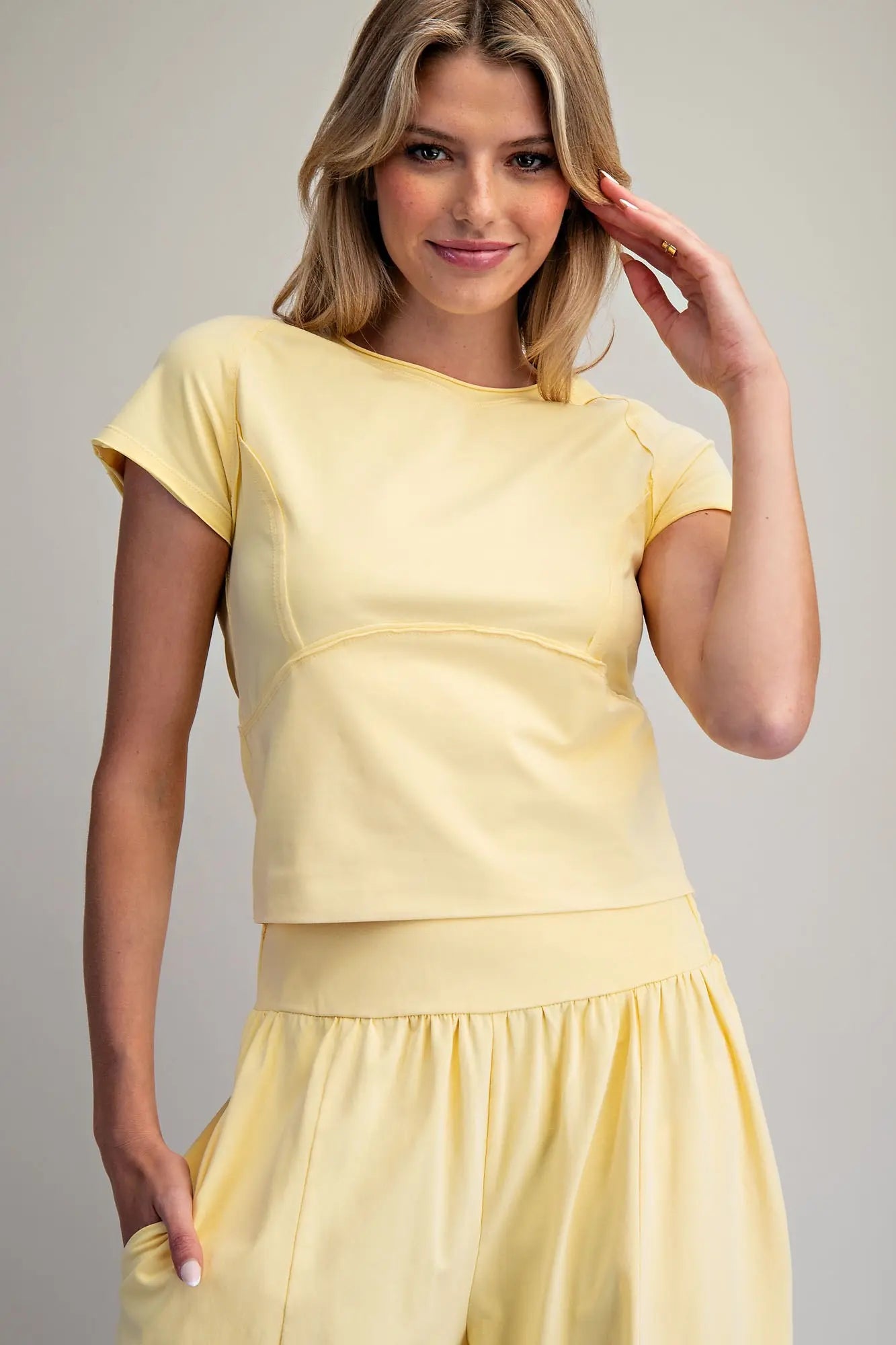 Woman wearing a yellow dress against a plain background