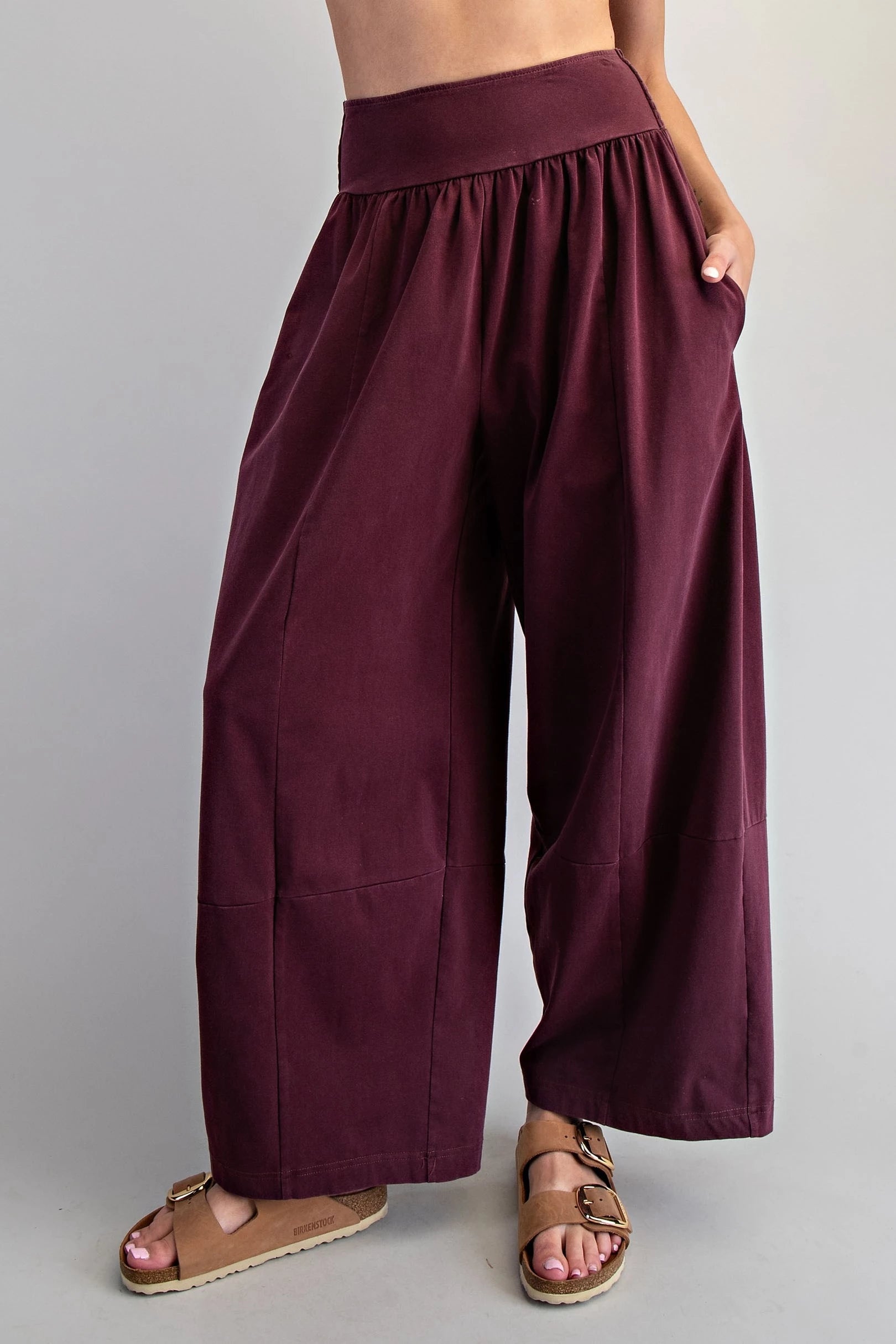 Maroon wide-leg pants worn by a person on a plain background