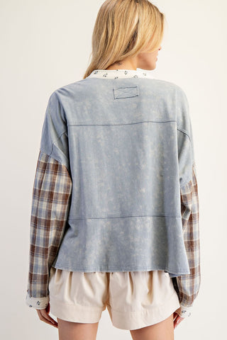 Woman wearing a light blue denim jacket with plaid sleeves on a white background