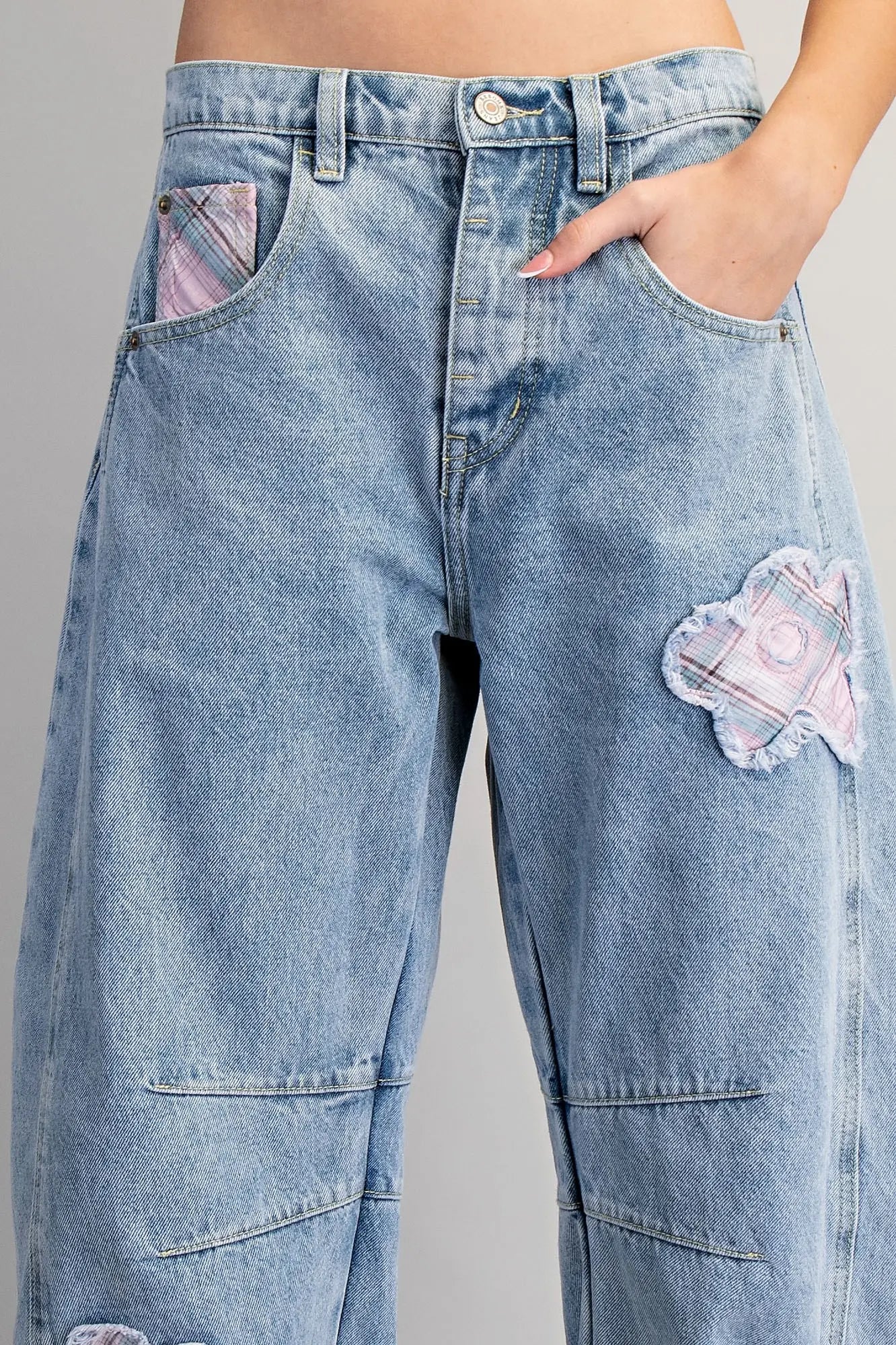 Blue jeans with patches on a gray background