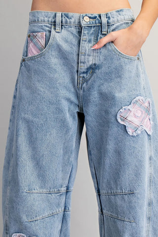 Blue jeans with patches on a gray background