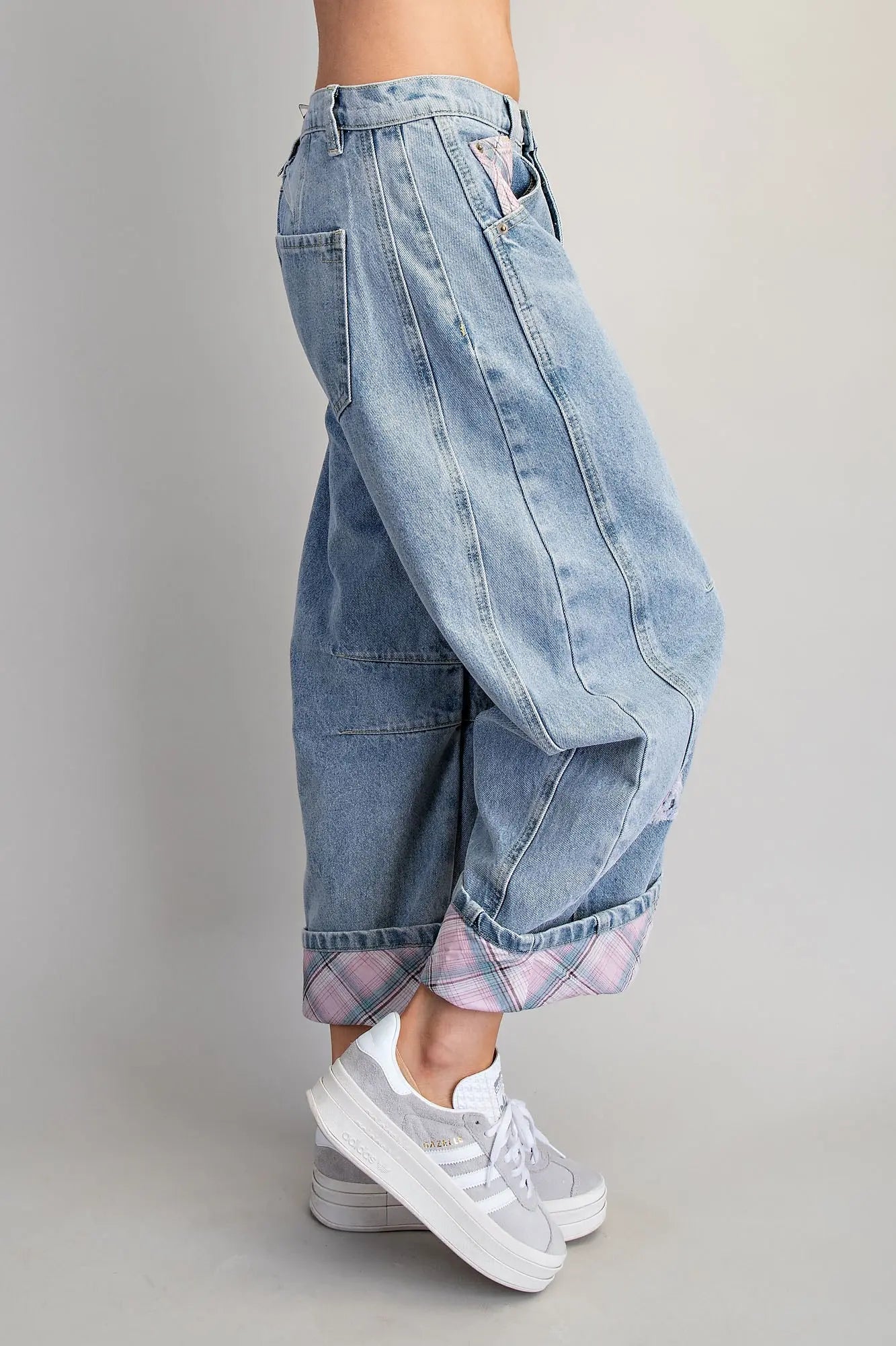 Light blue denim baggy pants worn by a person on a gray background